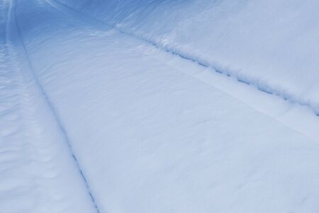 Abstract blue winter background. Tracks on snow.の写真素材