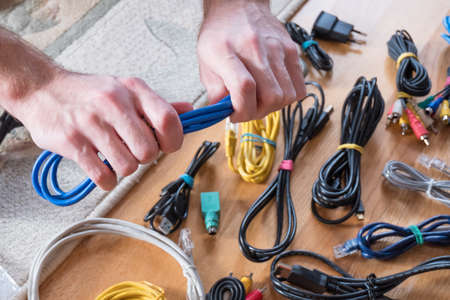 Male hands hold blue cableの写真素材