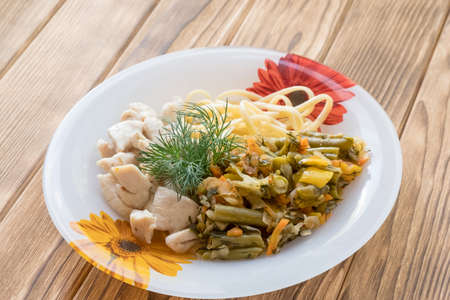 Chicken meat in a plate with fried vegetables and pastaの写真素材