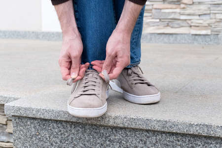 Mens hands tying laces ready for walkingの写真素材