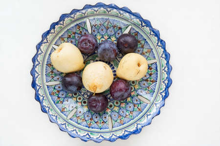 Pears and plums in an Uzbek bowlの写真素材