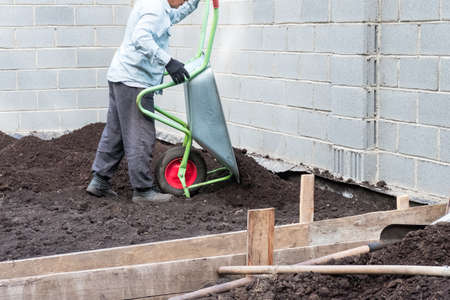 Work in the garden with a wheelbarrow and ground in gardenの写真素材
