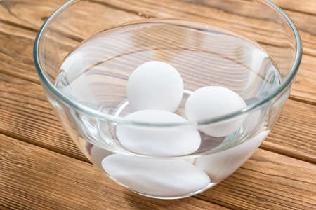 Raw eggs in a bowl with waterの写真素材