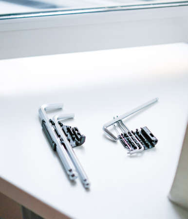 Tools on the windowsill to adjust the plastic window