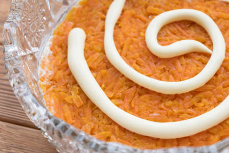 The process of cooking fish salad Mimosa. Laying carrots and mayonnaiseの写真素材