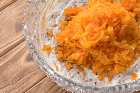 The process of cooking fish salad Mimosa. Laying carrots and mayonnaiseの写真素材