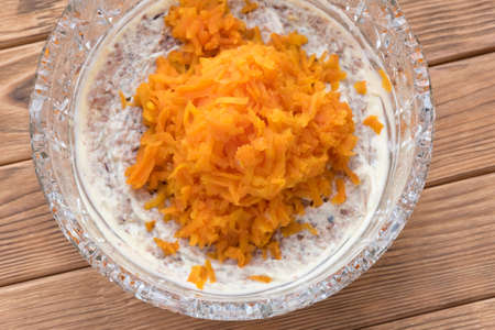 The process of cooking fish salad Mimosa. Laying carrots and mayonnaiseの写真素材