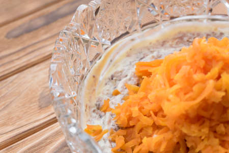 The process of cooking fish salad Mimosa. Laying carrots and mayonnaiseの写真素材