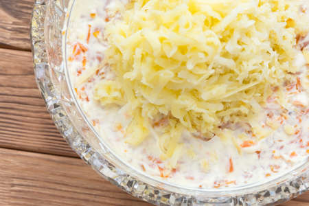 The process of cooking fish salad Mimosa. Laying potatoes and mayonnaiseの写真素材