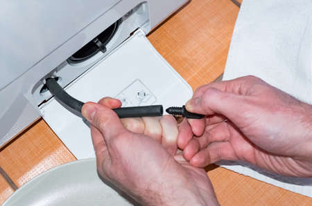 The master carries out the maintenance of the washing machine, cleaning the filterの写真素材