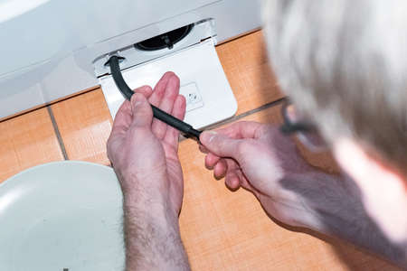 The master carries out the maintenance of the washing machine, cleaning the filterの写真素材