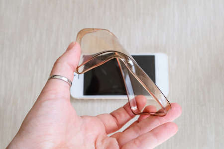 Silicone case for smartphone bent in his handの写真素材