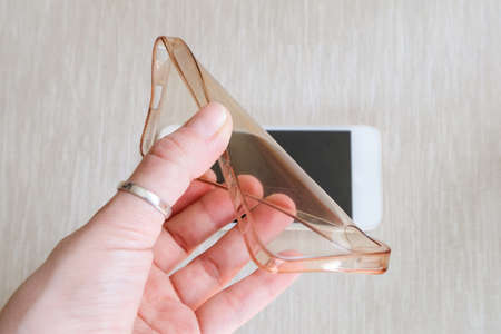 Silicone case for smartphone bent in his handの写真素材