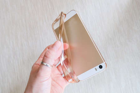 Silicone case for smartphone bent in his handの写真素材