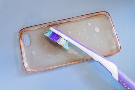 Cleaning the silicone phone case with toothbrush, foam and soapの写真素材