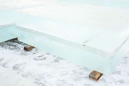 Ice cut into blocks for the construction of an ice town. Ice bricks lie on wooden props.の写真素材