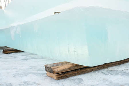 Ice cut into blocks for the construction of an ice town. Ice bricks lie on wooden props.の写真素材
