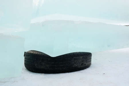 Ice blocks lie on rubber tires. Black tires as a stand. Ice for building an ice townの写真素材