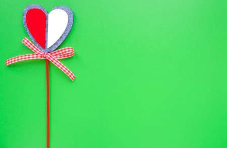 Valentine card on a green background. Heart on a stick.