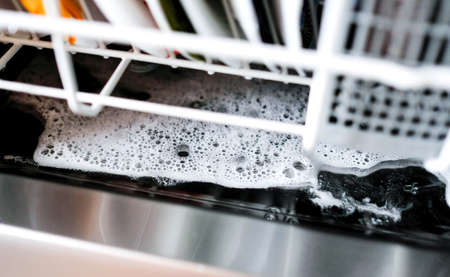 Excess detergent at the bottom of the dishwasher after washing. Foamの写真素材