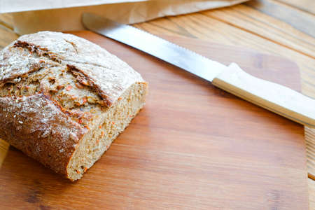 Carrot bread and a knife on the board. View from above. Brown tonesの写真素材