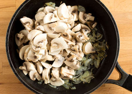 Mushrooms and onions in a pan. Fried mushrooms and vegetables in oil. Top view without peopleの写真素材