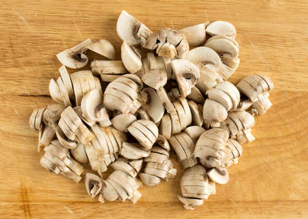 Sliced champignons on a cutting board. Edible mushrooms broken into piecesの写真素材