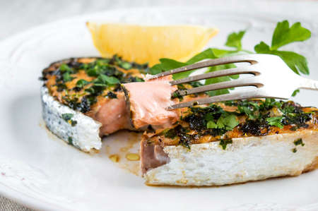 Try a delicious salmon steak. A piece of red fish on a forkの写真素材