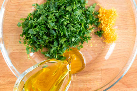 Pour oil in a plate with herbs and zest. Preparation of the marinade mixtureの写真素材