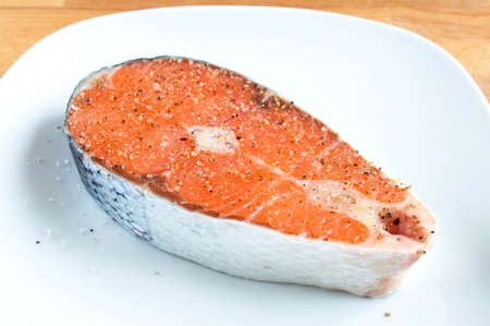 Raw salmon grated with salt and pepper. Red fish prepare for cookingの写真素材