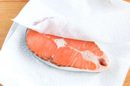 Salmon steak on kitchen towels. Red fish is prepared for cookingの写真素材
