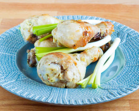 Appetizing chicken with green onions. Fried chicken drumstick in a plate. Serving dishesの写真素材