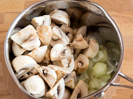 Add the mushrooms to the fried onions in the pan. Cooking Cream Soup.の写真素材