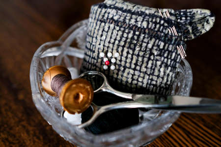 Tools for darning clothes. Scissors, spool of thread and pins in a crystal vaseの写真素材