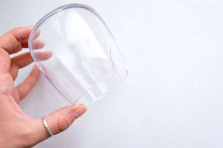 Crack in the glass. Holds a transparent glass in his hand. View from aboveの写真素材