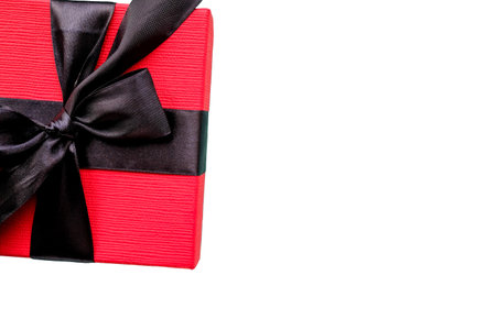 The red box is tied with a black wide ribbon. Gift on white background