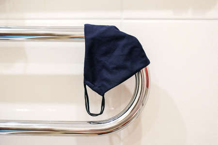 The mask is dried on a towel dryer. Curved iron pipeの写真素材