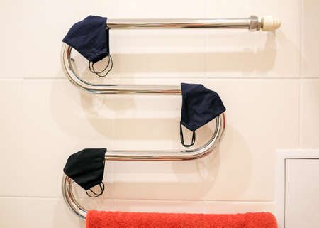 Fabric face masks are dried on a towel dryer.の写真素材