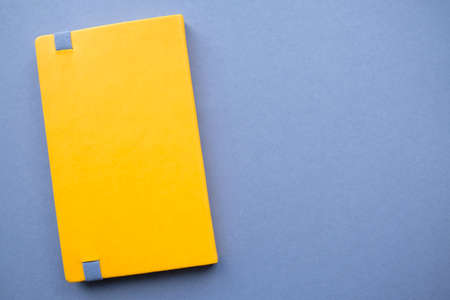 Bright yellow notebook on a solid dark background.