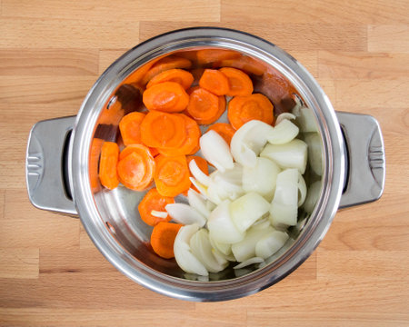 .Chopped onions and carrots in a saucepan. Preparation for frying.の写真素材
