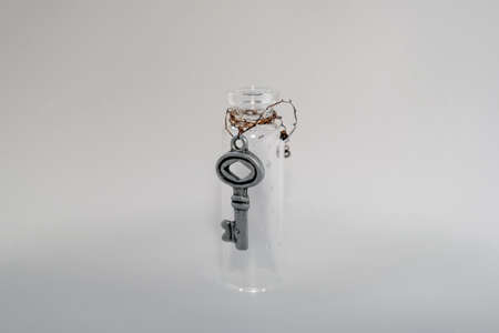 Small glass jar with an attached key.の写真素材