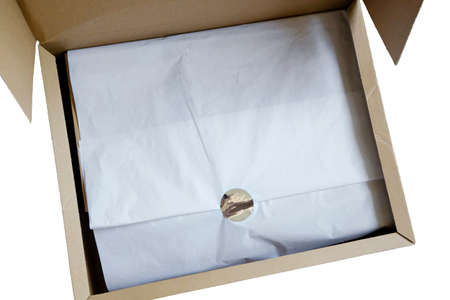 The box is open on a white background. Delivery of clothes, packaging with a sticker.の写真素材