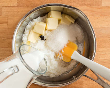 Cooking the pudding. Pour out milk, add butter and sugar.の写真素材