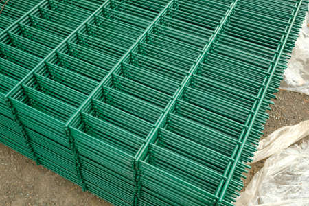 Fence sheets. Green bars lie on the road.の写真素材