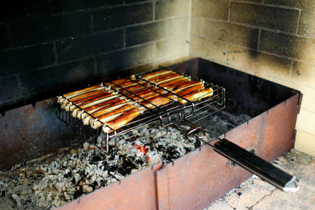 Meat sausages are fried in a special grill over charcoal. No people.の写真素材