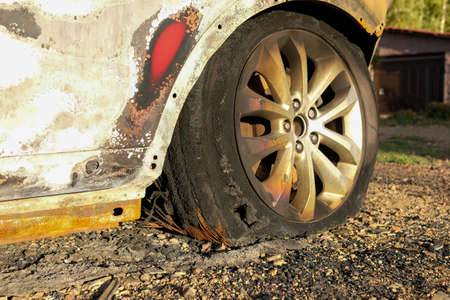Part of the car after a fire. Burnt wheel and rubber. No people.の写真素材