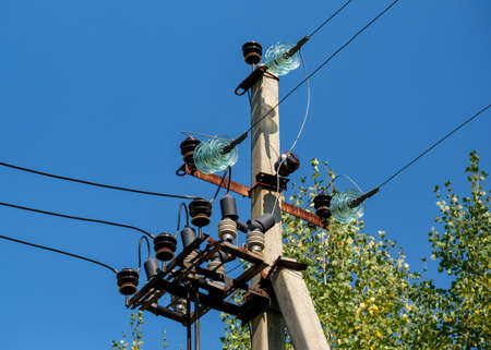 Electrical device on the pole. Wires and glass mounts and arresters. Blue sky.の写真素材