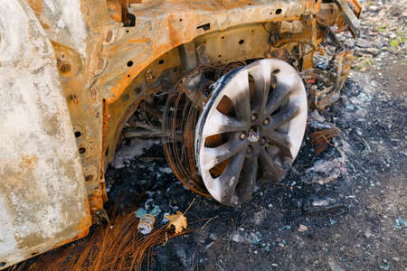 Burnt car wheel stands on the ground.の写真素材