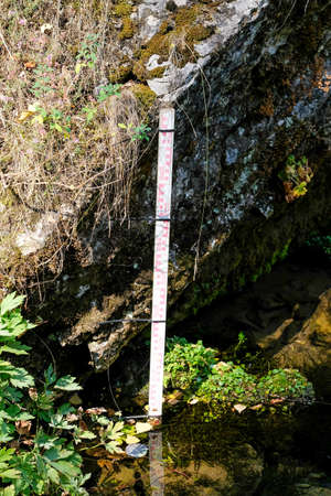 Measuring the water level on a wooden scale in the lake. No people.