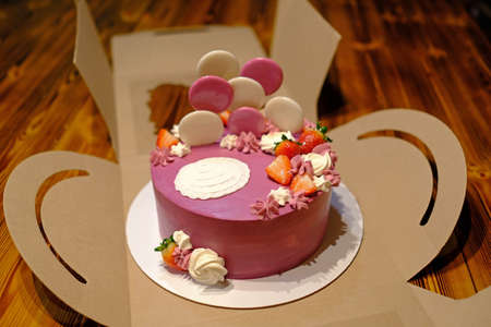 A beautifully decorated birthday cake for a girl. Stands on a cardboard box.の写真素材